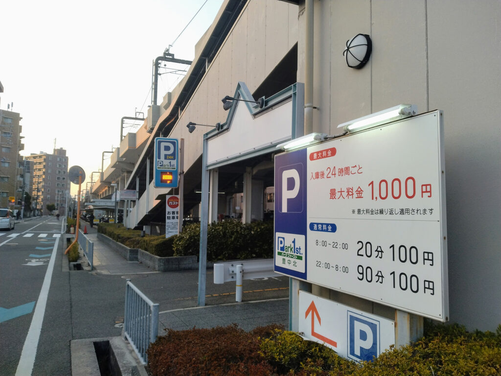 豊中駅の8番出口からの交差点で線路沿いにある駐車場の写真
